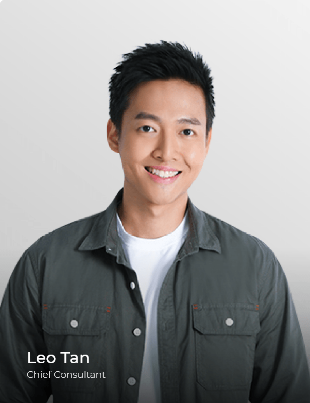 Smiling man in a grey shirt against a plain light background.