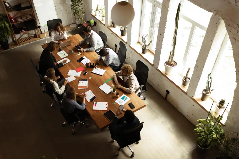 Team meeting at a desk discussing a white label marketing partnership plan.